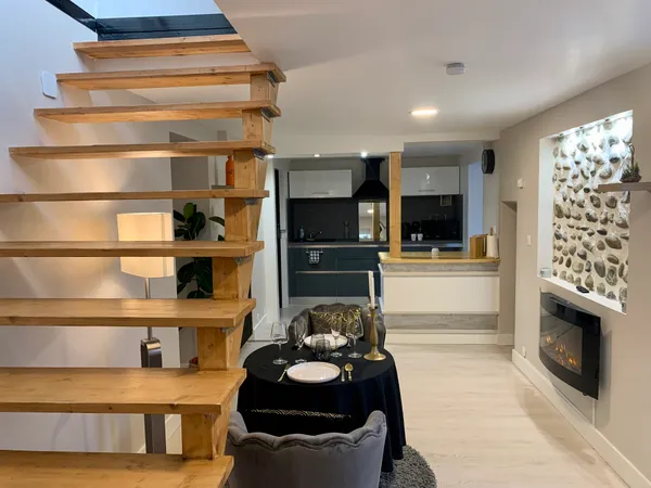 Salon avec cheminée électrique et table dressée pour deux